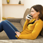 A woman at home drinking a cup of green tea.